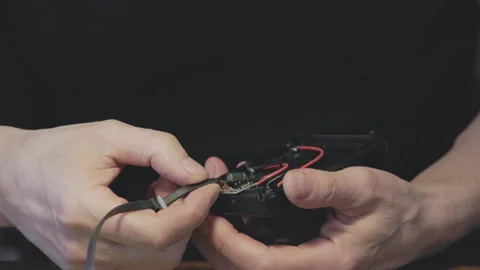 An Intimate CloseUp View of Hands Engaged in the Assembly of Electronic Device Stock Footage 320950649