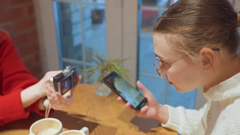 Intimate gathering discussing images with cups of coffee nearby. Relaxed friends Stock Footage 335760028