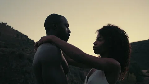 Intimate hug between two people during sunset in a serene outdoor setting Stock Footage 319907129