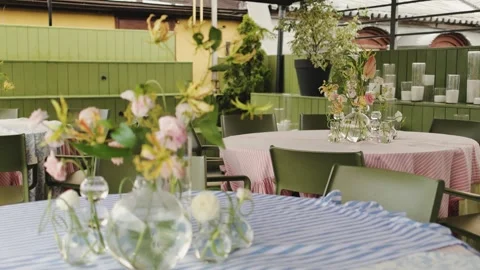 Intimate pastel tables under canopy with hanging lights and candle display, low Stock Footage 325843666