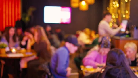 Intimate restaurant scene with warm lighting. Nighttime gathering with shared 스톡 동영상 328378642