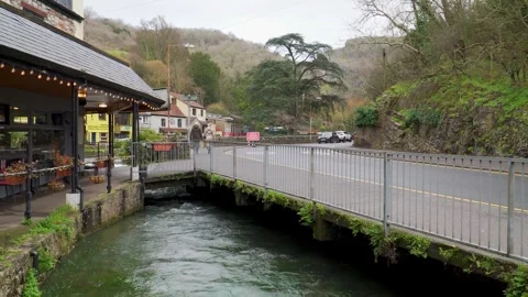 Intimate riverside angle of crystal water moving steadily beneath a low bridge Stockbeeldmateriaal 331229595