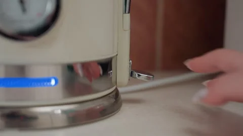Intimate scene of someone activating kettle on new apartment counter. Quiet Vidéo 346225368