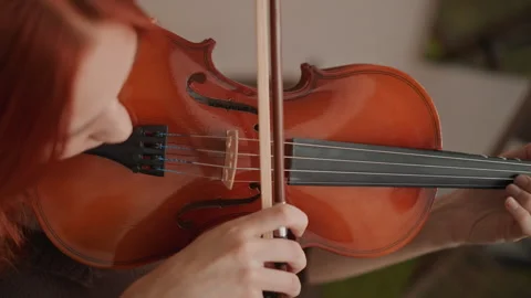 Intimate scene of student practicing violin attentively indoors. Closeup of Stock Footage 346555806