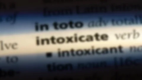 Intoxicate word in a dictionary. Stock Footage 99561495