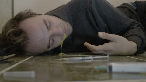 Intoxicated young boy lying on the bathroom floor spasm unconsciously and vom Stock Footage 86879897