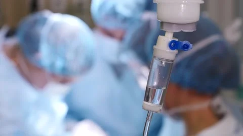 Intravenous drip and surgeons in the background, Close-up, 4k footage Stock Footage 55961719
