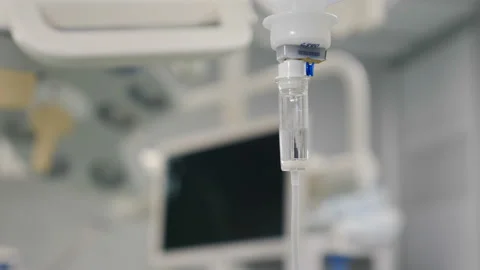 Intravenous drip in focus,surgeons team performing operation, infusion dripping Stock Footage 166364197