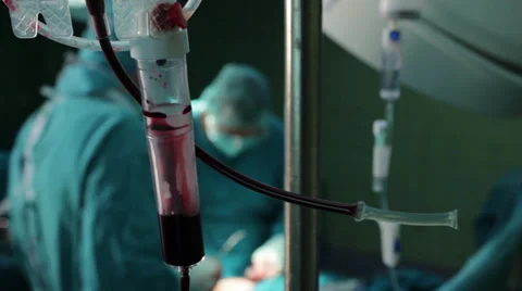 Intravenous drip in operation room with surgeons on background. Iv drip close up Stock Footage 34963526