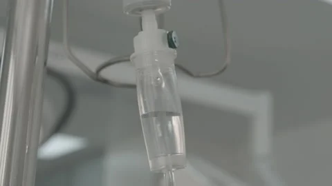 Intravenous drip, surgeons team performing operation in the background, infusio Video stock 143160295