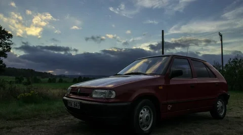 Intresting clouds moving towards the camera. Red Skoda Felicia -time lapse Stock Footage