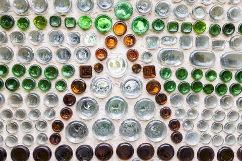 Intricate decorative pattern created from recycled glass bottles embedded i.. Stockfoto's