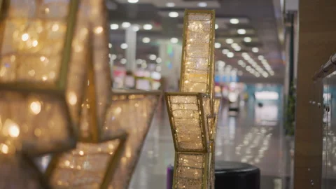 Intricate Gold Frames Illuminated by Warm Light in Blurred Mall Interior Stock Footage 300999697