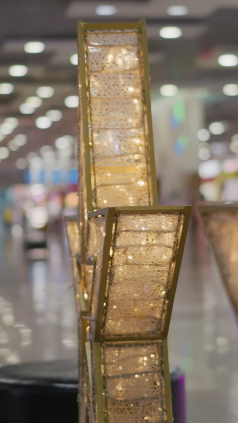 Intricate Gold Frames Illuminated by Warm Light in Blurred Mall Interior Stock Footage 310576423