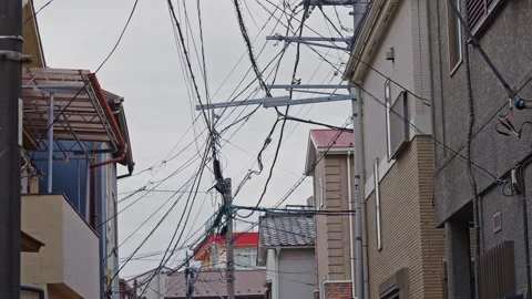 Intricate network of overhead utility power lines and cables in an urban Stock Footage 333097247