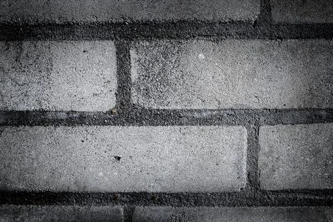 Intricate patterns of gray concrete bricks create a rough urban texture in .. Foto stock