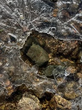 Intricate Patterns of Ice Forming Over Rocks in a Clear Natural Setting Stock Photos