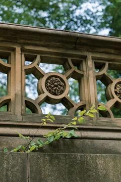 Intricate stone railing with decorative patterns in a lush greenery setting Stock Photos