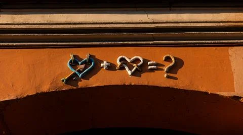 An intricately designed brick wall featuring a heart and a question mark Stock Photos