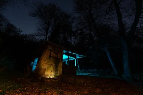 An intriguing night shot of a small, rustic structure nestled at the edge of Stock Photos