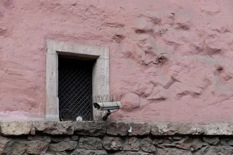 An Intriguing View of a Window Surrounded by a Textured Pink Wall Featuring a Foto stock