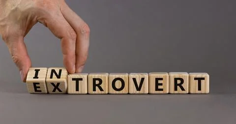 Introvert or extrovert symbol. Hand turns cubes and changes the word 'introve Stock Photos