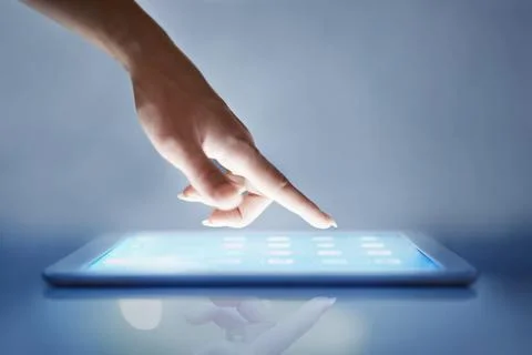 Intuitive technology. Cropped closeup of a womans hand above a digital tablet Stock Photos