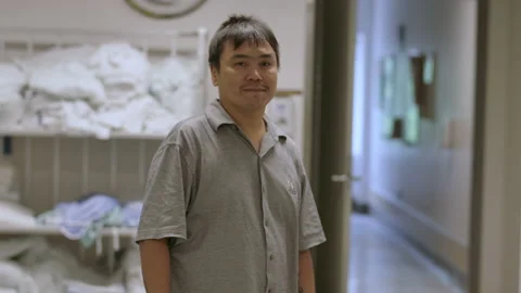 Inuit man turning to face the camera with a smile in a hospital Stock Footage 218636201