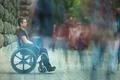 The invalid man sit in the wheel chair in the crowd stream at sidewalk Photo