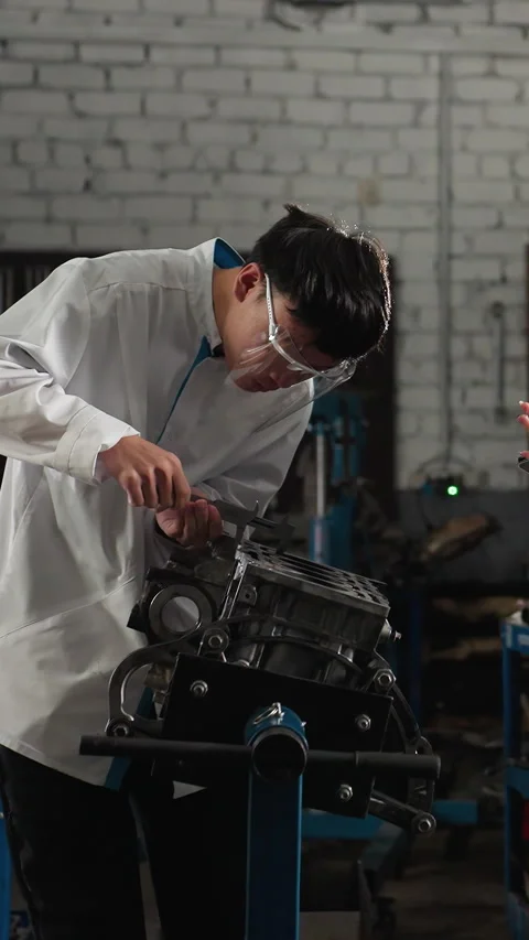 Inventor Measuring Engine Thickness While Colleague Records Data in Mechanical 動画素材 318255122