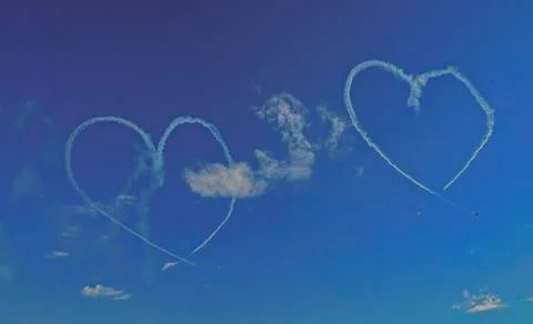 Inversion trail of the plane. A small plane makes a heart figure Stock Photos