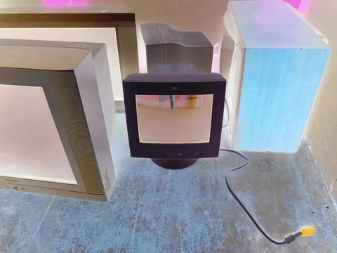 Inverted image - Multiple old computer monitors and TVs inside of electric waste Foto stock