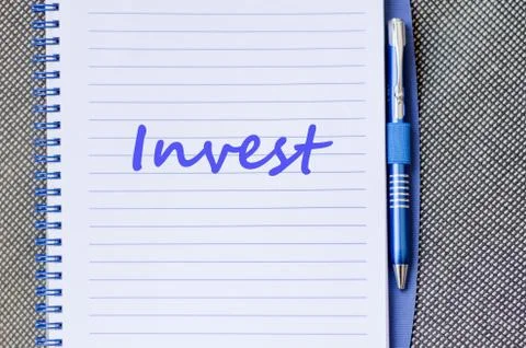 Invest write on notebook Stock Photos