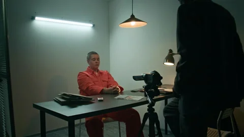 Investigator Beginning Interview with Inmate with Camera in Interrogation Room Stock Footage 311844253