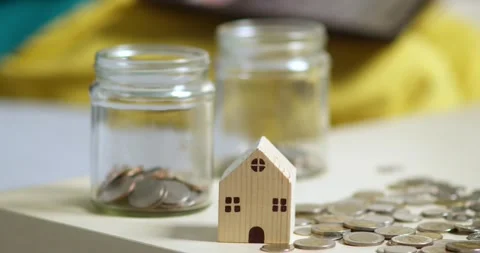 Investing in your future saving coins for a house home office close-up view Stock Footage 336637569