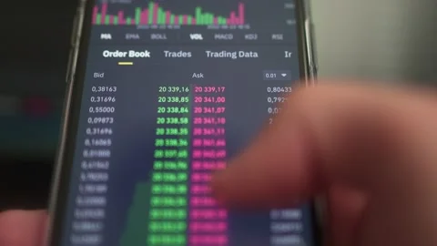 Investor checks the value of cryptocurrency on mobile phone. Using phone to Stock Footage 199247264
