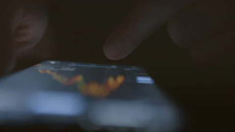 An investor-trader looks at the changes in the digital chart of the fall process Stock Footage 235559323