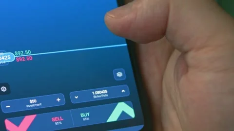 Investor using smart phone analyzing financial data crypto stock market, coin Stock Footage 249932545