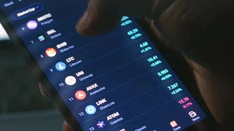 Investor using smart phone analyzing financial data crypto stock market, price Stock Footage 249939191