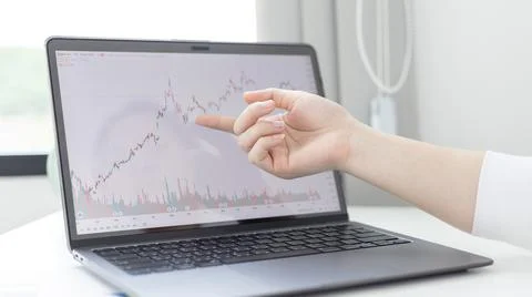 Investors sit and watch graphs of stock market data and watch the world marke Stock Photos