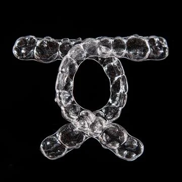 Invisible aligner teeth retainers on a black background Stock Photos