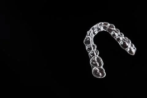 Invisible aligner teeth retainers on a black background Stock Photos