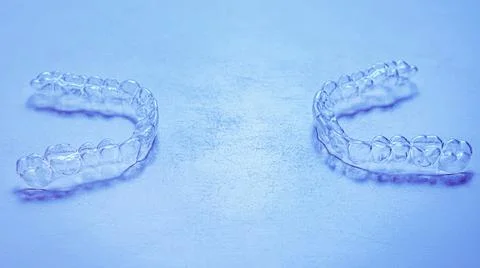 Invisible aligner teeth retainers on a blue background Stock Photos