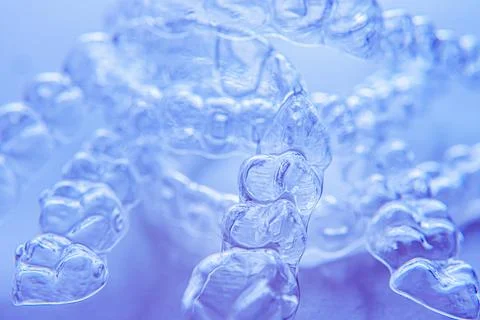 Invisible aligner teeth retainers on a blue background Stock Photos