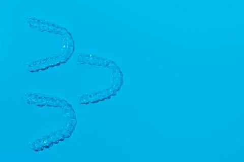 Invisible aligner teeth retainers on a blue background Stock Photos