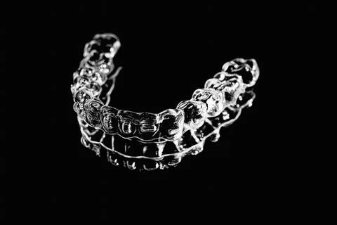 Invisible aligner teeth retainers lie on the mirror in orthodontic office. Ph Stock Photos