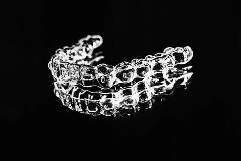 Invisible aligner teeth retainers lie on the mirror in orthodontic office. Ph Stock Photos