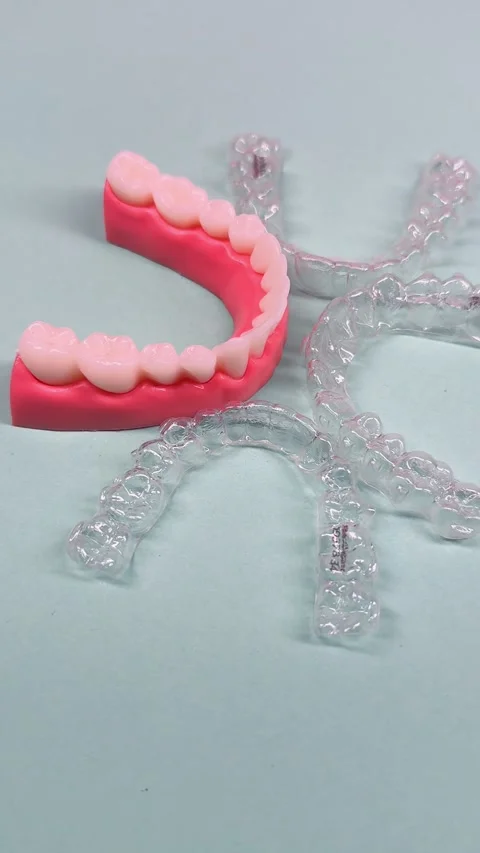 Invisible dental teeth brackets tooth aligners on blue background. Plastic .. Stock Footage 318591729