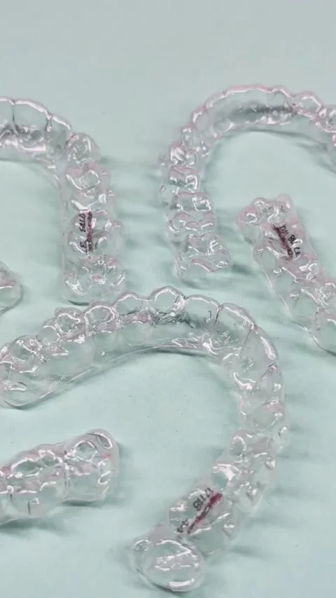 Invisible dental teeth brackets tooth aligners on blue background. Plastic .. Stock Footage 318591731