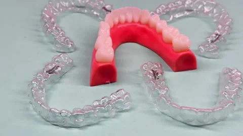 Invisible dental teeth brackets tooth aligners on blue background. Plastic .. Stock Footage 318591733